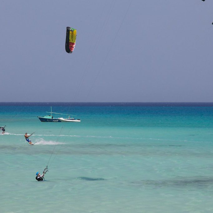 Several kitesurfers on a shallow turquoise lagoon near Hurghada